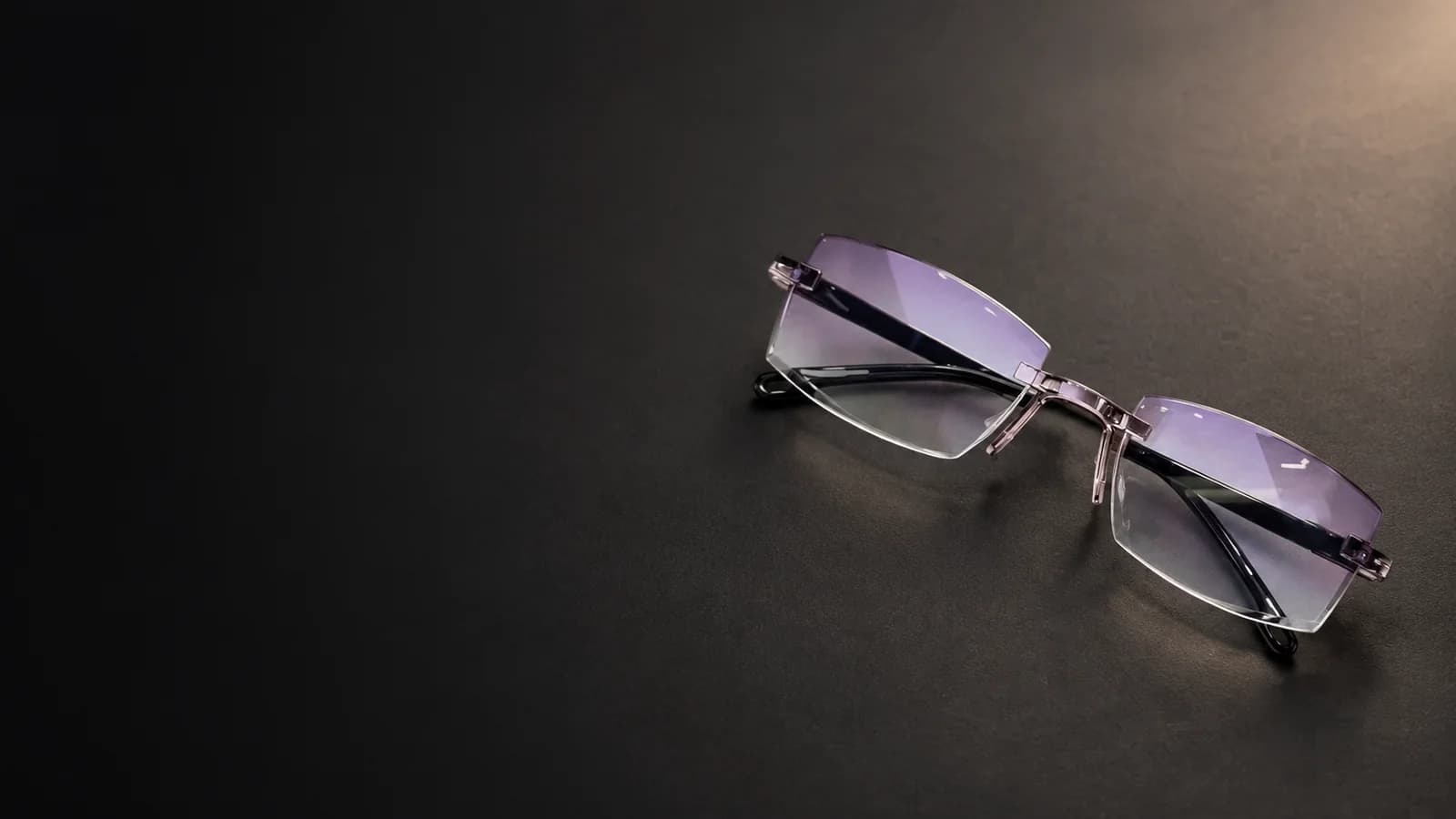 Rimless reading glasses with angular lenses and dark temples.
